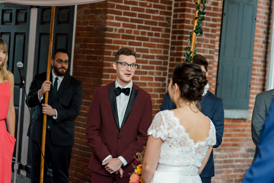 A groom greets his bride under the chuppah.